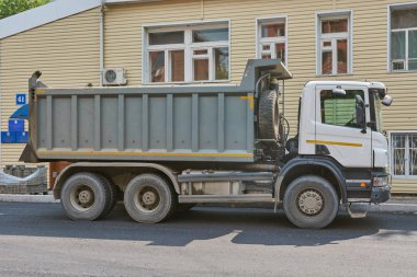 Krasnoyarsk, Russia - July 26, 2018: SCANIA truck delivered stones for laying of sidewalks, Lenina street. clipart