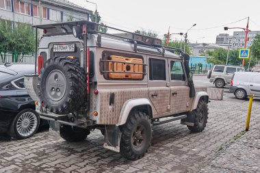 Krasnoyarsk, Rusya Federasyonu - 22 Ağustos 2018: Land Rover Defender araba üzerinde katılımcının gelenler house yakınındaki Park üzerinde yol arazi duruyor. Arka sağdan görünüm.