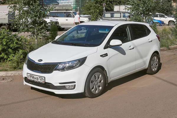 Krasnoyarsk, Rusya Federasyonu - 21 Ağustos 2018: Kia Rio araba araba park ofis ve ticari yapılar üzerinde duruyor. Önden görünüm.