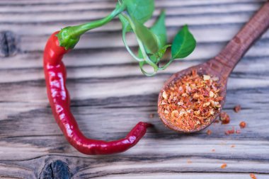 Kırmızı biber tozu ve masa arkasında taze ve kurutulmuş biber.