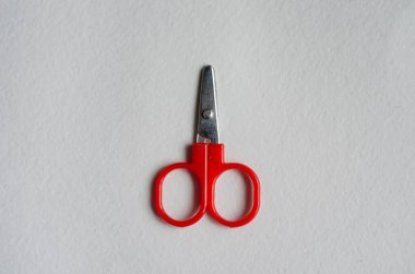 Kağıt zemin üzerinde sevimli kırmızı makas kapalı yatıyor