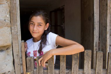 Beautiful young girl in rural house in Honduras with a peaceful smile.  clipart
