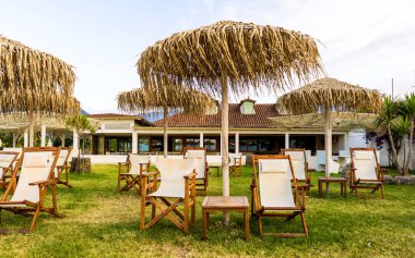 Saman şemsiye ve şezlong resort turistler için bekleyen. Rüya gibi tatil resmi.