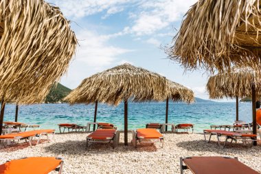 Saman şemsiye şezlong üzerinde bir deniz kıyısı ile. Tatil ideallic resim sakin ol.