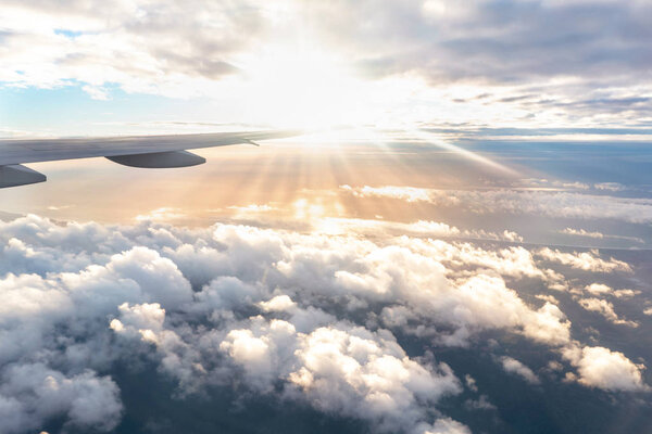 Spectacular sunset view from the airplane window with puffy clouds and ocean on background
.