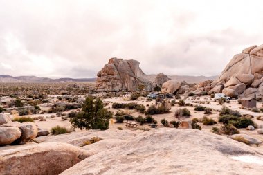 Kervanlar ile bir kamp alanı etrafında olağanüstü kaya oluşumları ile Joshua Tree Milli Parkı manzara. California, Amerika Birleşik Devletleri.