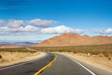 Ufukta inanılmaz dağlar ve bulutlar ile Mojave Çölü karayolu manzara. California, Amerika Birleşik Devletleri.
