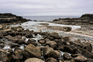Bosdalafossur Şelalesi, Atlantik Okyanusu 'na akan su ile kenar. Vagar, Faroe Adaları, Danimarka.