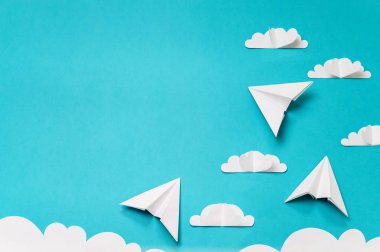 Kağıt bulutlar ve origami uçaklar kesti. Afiş/iniş/arka plan tasarımları için yaratıcı konsept.