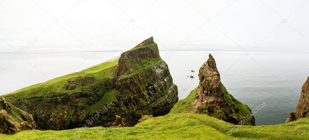 Panoramic landscape of Mykines island. Lighthouse and Atlantic Ocean on background.