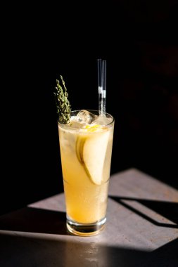 Şaşırtıcı ışık ve derin siyah arka plan ile demir bir masada armut limonata bir bardak.