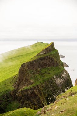 Kayalıklar ve yuvalama kuşlar ile Mykinesholmur dikey resim. Mykines, Faroe Adaları.