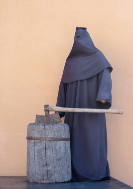 Siyah elbiseli, baltalı bir cellat.