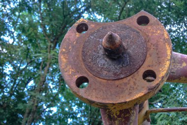 İnşaat vincinin bir parçası. Paslı disk ve borular. Yuvarlak delikli.,