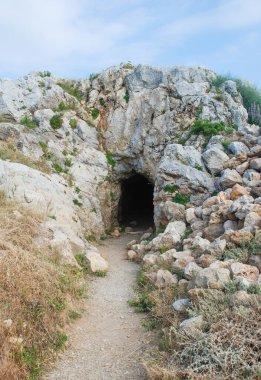 Karanlık bir kayalık mağaranın girişine giden yol, kaya, mağara.