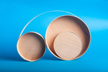 Açık mavi arka planda, kenarda duran üç farklı boyutta tahta kutu..