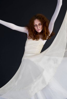 Cadılar bayramı için bir görüntü, beyaz elbiseli, soluk yüzlü, kızıl saçlı bir kadın.