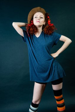 Saçları örgülü ve çizgili golf sahaları olan, çocuksu komik bir kadın.