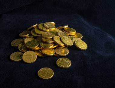 Sarı para yığını, Ukrayna para birimi, koyu kadife arka planda.