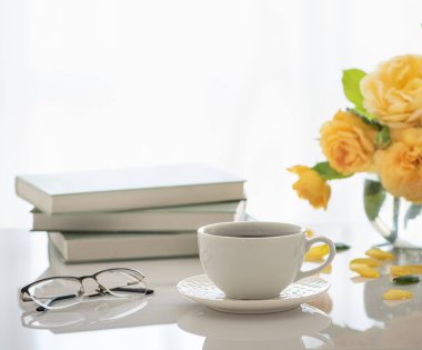 Bir fincan kahve. İyi sabahlar. Çay zamanı. Kitaplarda kahve olan bir fincan. Bir kitap ve kahveyle günaydın. Rahat ol. Sarıl..