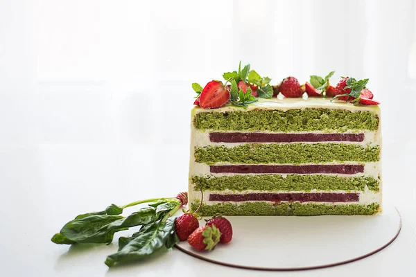 Beyaz arka planda yarım veya bir dilim lezzetli taze pasta. Çilekli pasta. Ispanaklı çilekli kek. Çilekli ve kremalı yeşil pastalar. sünger keki