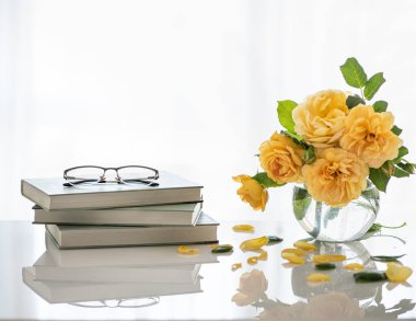 Bardaklar kitaba. Dinlenme zamanı. Masanın üzerinde bir vazo çiçek..