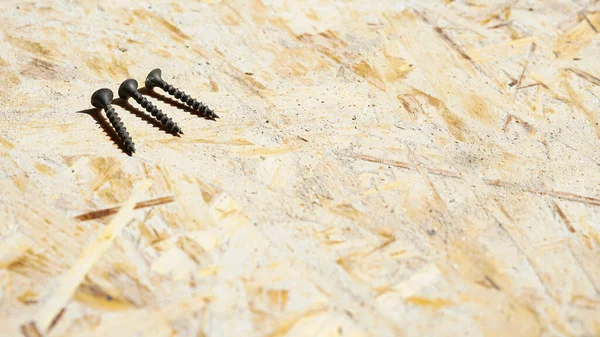 Three Black Metal Tapping Screws Lie Wooden Surface Free Space — Stock Photo, Image