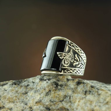 Siyah arka planda gümüş adam yüzüğü.