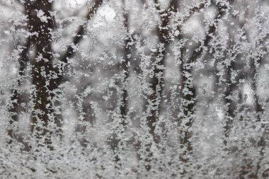 Penceresinde kar ve kar taneleri ve arka planda buz kristalleri olan kış penceresi.