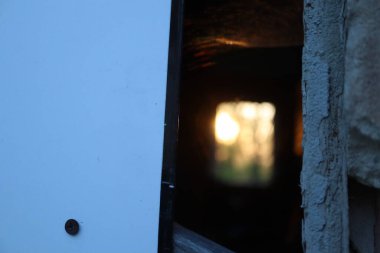 Akşamları terk edilmiş bir binanın penceresindeki eski ahşap kapı.