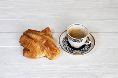 Bir fincan kahveli kruvasan.