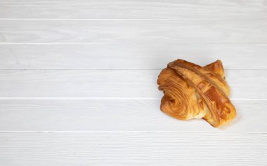 Beyaz ahşap arka planda taze kruvasan