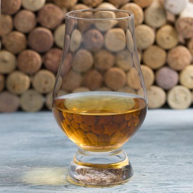whiskey in a glass in which corks are reflected clipart