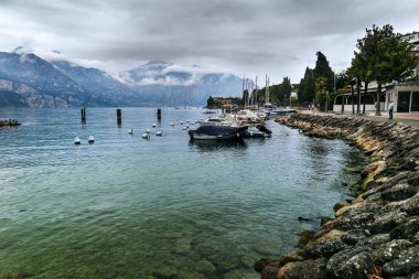 Malcesine, İtalya - 1 Ekim 2018: Görünüm Garda Gölü ve Alpler, bulutlu bir sonbahar günü şehirde sahil.