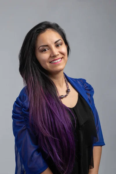 portrait of a latin woman with purple hair and blue clothes, happy