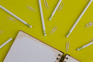 Kalemler, ataçlar, ve bir defter, eğlenceli renkli arka planda ofis nesneleri