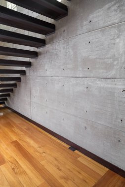 Tribünlerin altı, ahşap zemin ve gri duvar