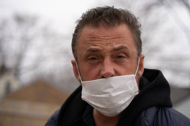 Coronavirus sırasında maske takan beyaz bir adam.
