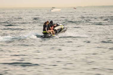 Kişisel su araçları güneşli bir günde Metro Parkı 'nda eğleniyor ve numaralar yapıyor.