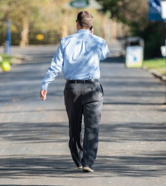 Bilinmeyen işadamı öğle yemeği molasında hareketli bir yürüyüş yapıyor.