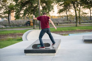 Detroit, Michigan, ABD - 10.07.2019: Patenciler ve motosikletçiler Detroit 'teki kaykay parkında gün batımında numara yapıyorlar