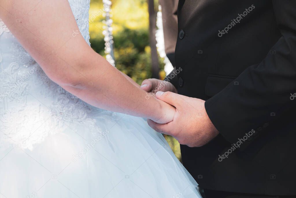 bride and groom hold hands during their vows