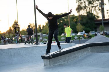 Detroit, Michigan, ABD - 07.14.2019: Patenciler gün batımında Detroit 'teki kaykay parkında numaralarını çalışıyorlar