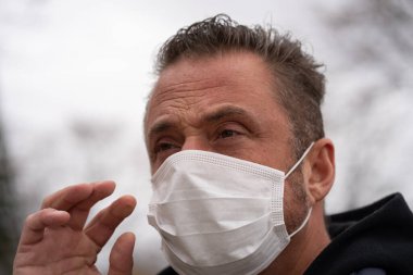 Coronavirus sırasında maske takan beyaz bir adam.