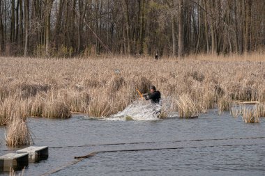 Harrison Township, Michigan, ABD - 02 Mayıs 2020: Uçurtma sörfçüleri ve rüzgar sörfçüleri Michigan Metro Parkı 'nda rüzgarlı bir günde pratik yapıyorlar.