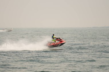 Kişisel su araçları güneşli bir günde Metro Parkı 'nda eğleniyor ve numaralar yapıyor.