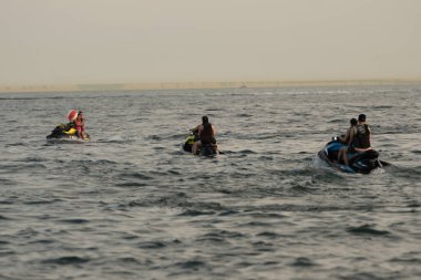 Kişisel su araçları güneşli bir günde Metro Parkı 'nda eğleniyor ve numaralar yapıyor.