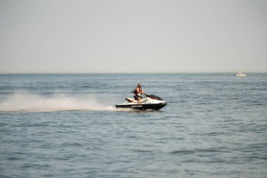 Kişisel su araçları güneşli bir günde Metro Parkı 'nda eğleniyor ve numaralar yapıyor.