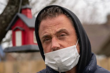 Coronavirus sırasında maske takan beyaz bir adam.