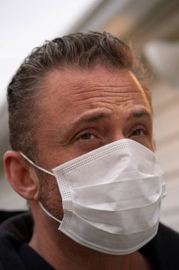 Coronavirus sırasında maske takan beyaz bir adam.